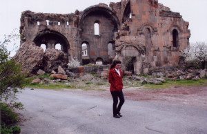 Woman walks by the dilapidated church in Ptghni which continues to remain a citadel in this tiny village of Armenia.
