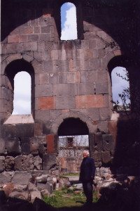 Woman walks by the dilapidated church in Ptghni which continues to remain a citadel in this tiny village of Armenia.