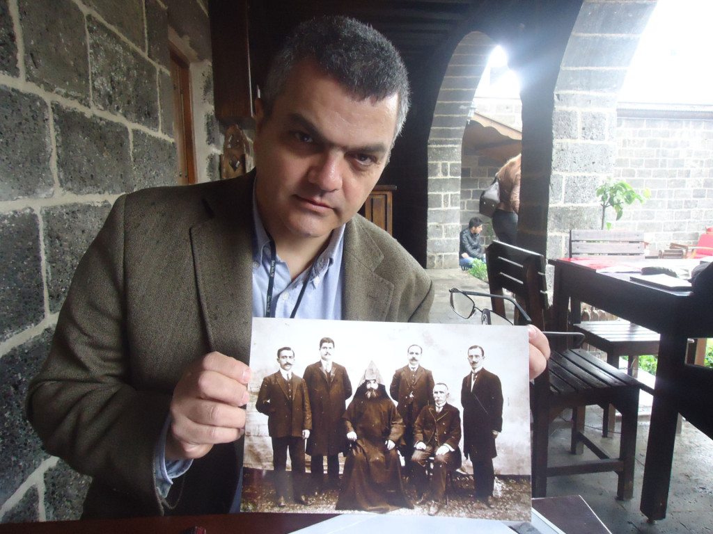 Ara Sarafian in Diyarbakir holding a photograph from the genocide (Photo by Gulisor Akkum, The Armenian Weekly)