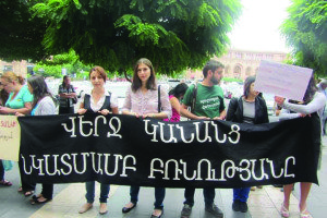 Activists hold a banner that reads, "End violence towards women," during a protest in Yerevan (Photo credit: Society Without Violence)