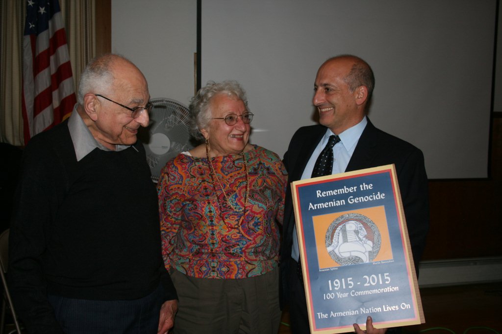 Community activist George Aghjayan is presented with a commemorative poster of the Armenian Genocide designed by artist Martin Barooshian and his wife Mary during an Armenian Independence Day celebration Sept. 20 in Lowell.