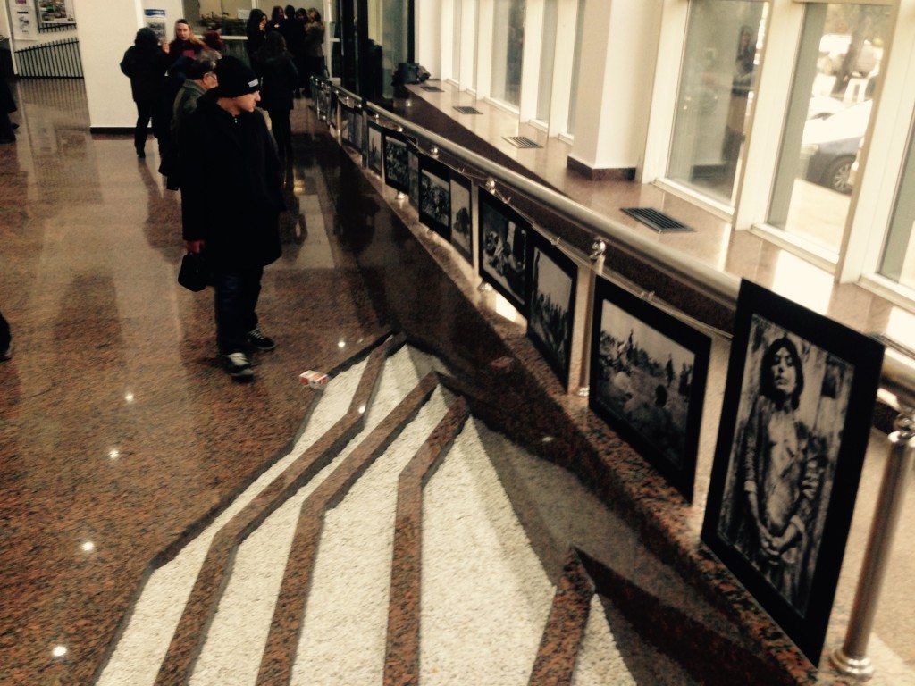Conference goers walk by photographs depicting the horrors of the Armenian Genocide. (Photo by Eric Nazarian)