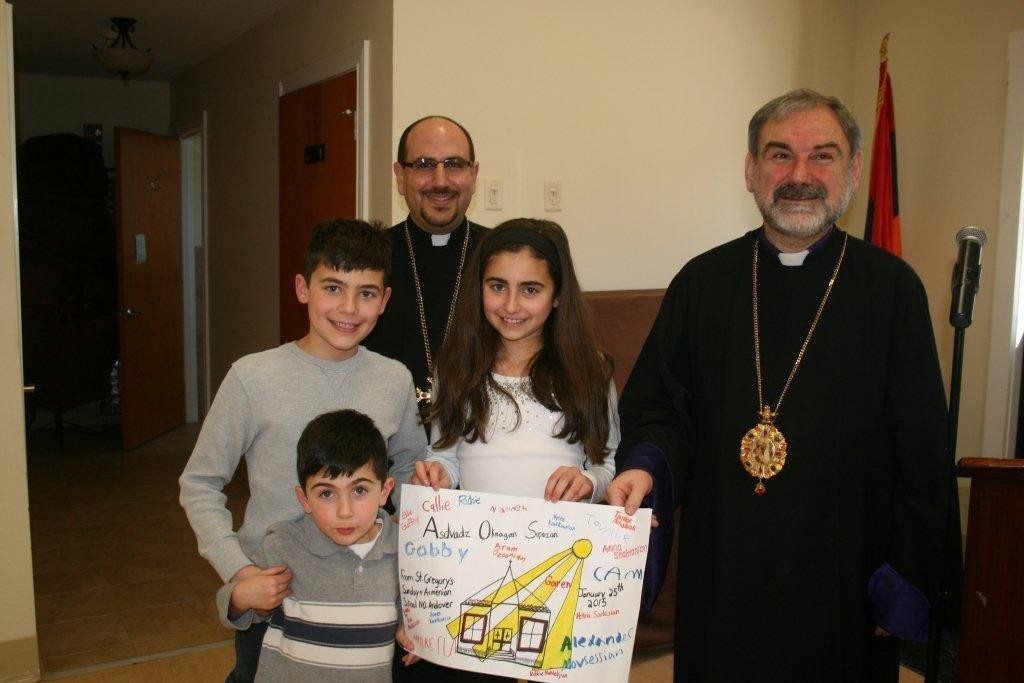 Bishop Anoushavan Tanielian is presented artwork by the children of St. Gregory Church in North Andover during a visit commemorating the parish’s 45th anniversary.