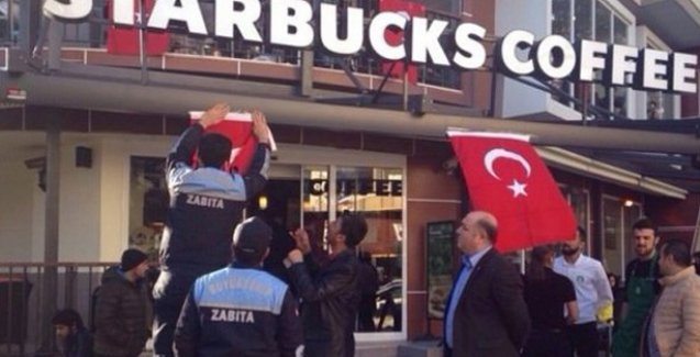 Police hang Turkish flags at the entrance of Starbucks locations across Adana