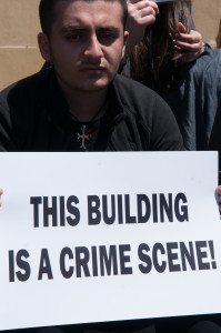 A man holds a sign reading, 'This building is a crime scene,' at the Haydarpasha train station (photo: Matthew Karanian)