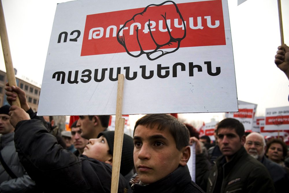 A protester holds a sign that reads, 'No to the Turkish preconditions,' in a demonstration held in Yerevan in 2009 (photo by Inna Mekhitarian-Hairenik/Armenian Weekly)