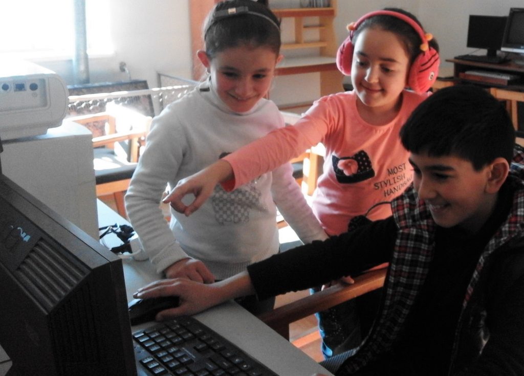 Gargar secondary school children are joyfully discussing their first coding project.
