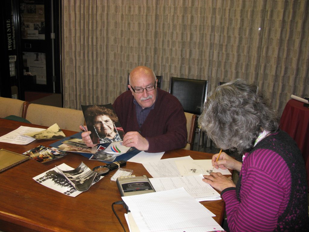 March 1, 2011, with tape recorder running, and Suzanne Adams, Archivist, taking the photo, Tom shares a photo he took of his mother, Ojen ‘Jennie’ Hekimian Vartabedian, and shares her accomplishments as a Genocide Survivor with Ruth.